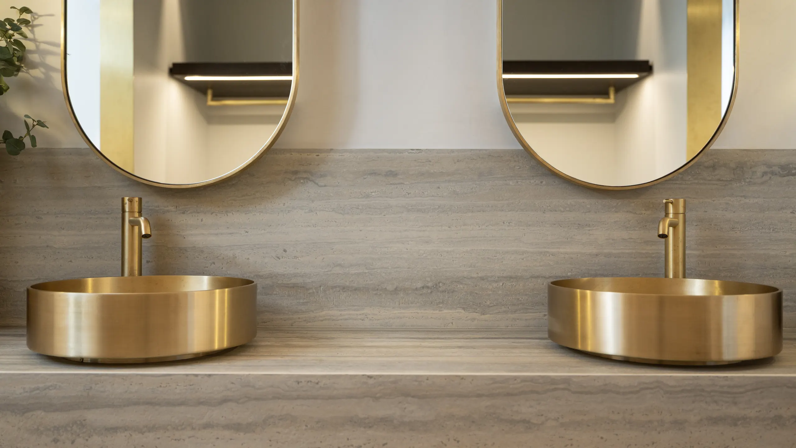 Brushed brass basins and tapware with brass-framed mirrors on a travertine vanity — FOCAL metalwork, Bunker 3, Queenstown